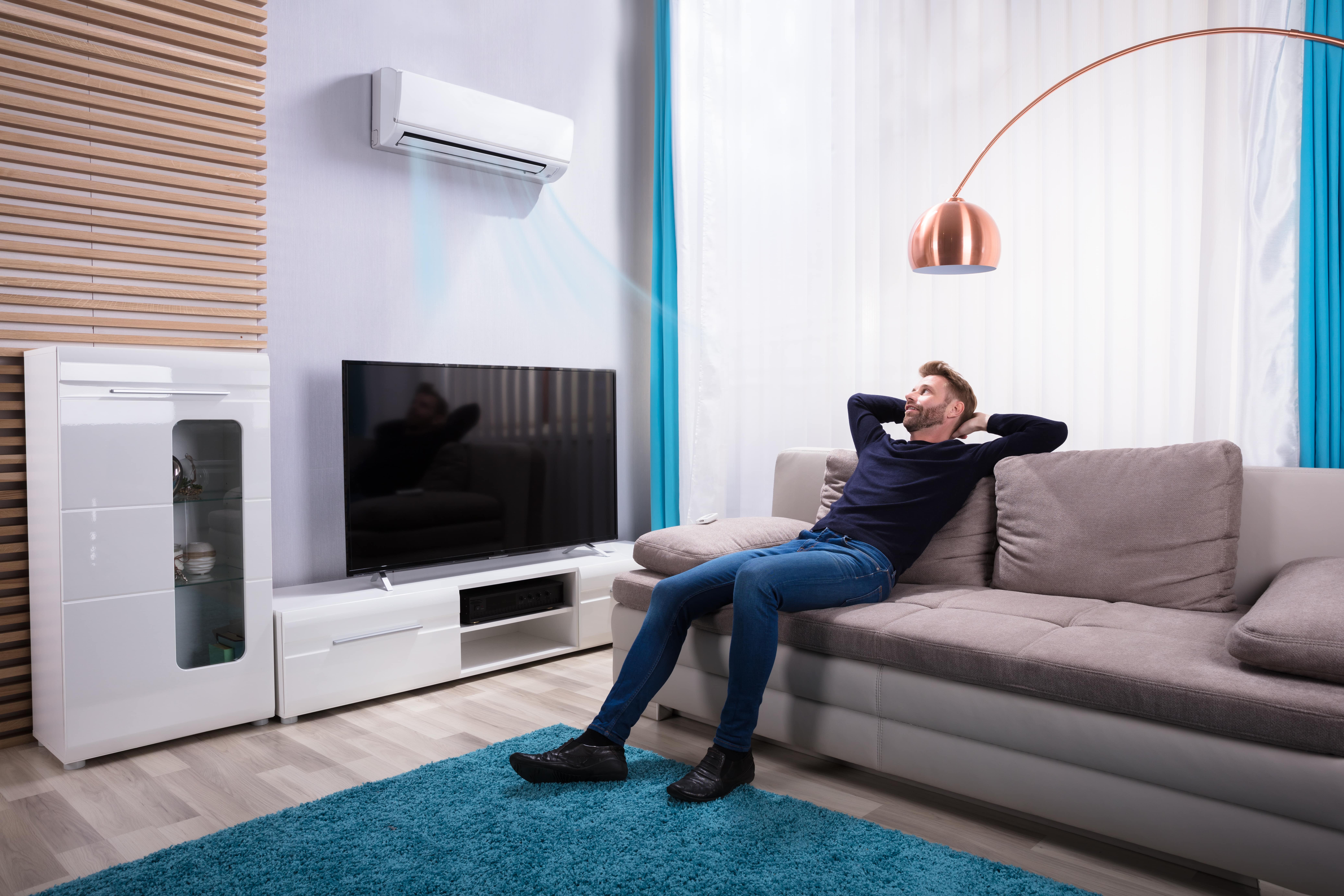 A man sitting down on a couch and enjoying his new AC.
